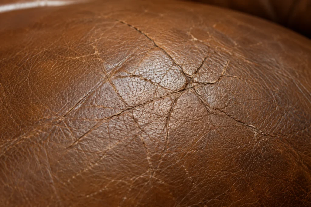Fine crazing in the topcoat of a leather armchair, seen up close