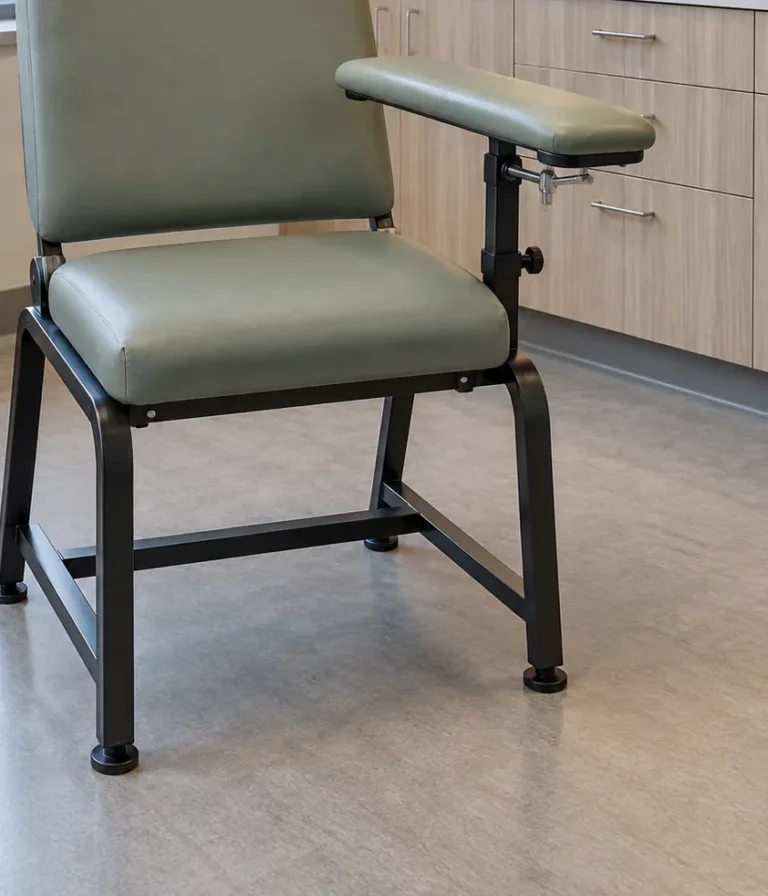 A sage green blood draw chair with a padded swing arm